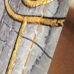 Met oranje garen in de rug gesingerd, detail